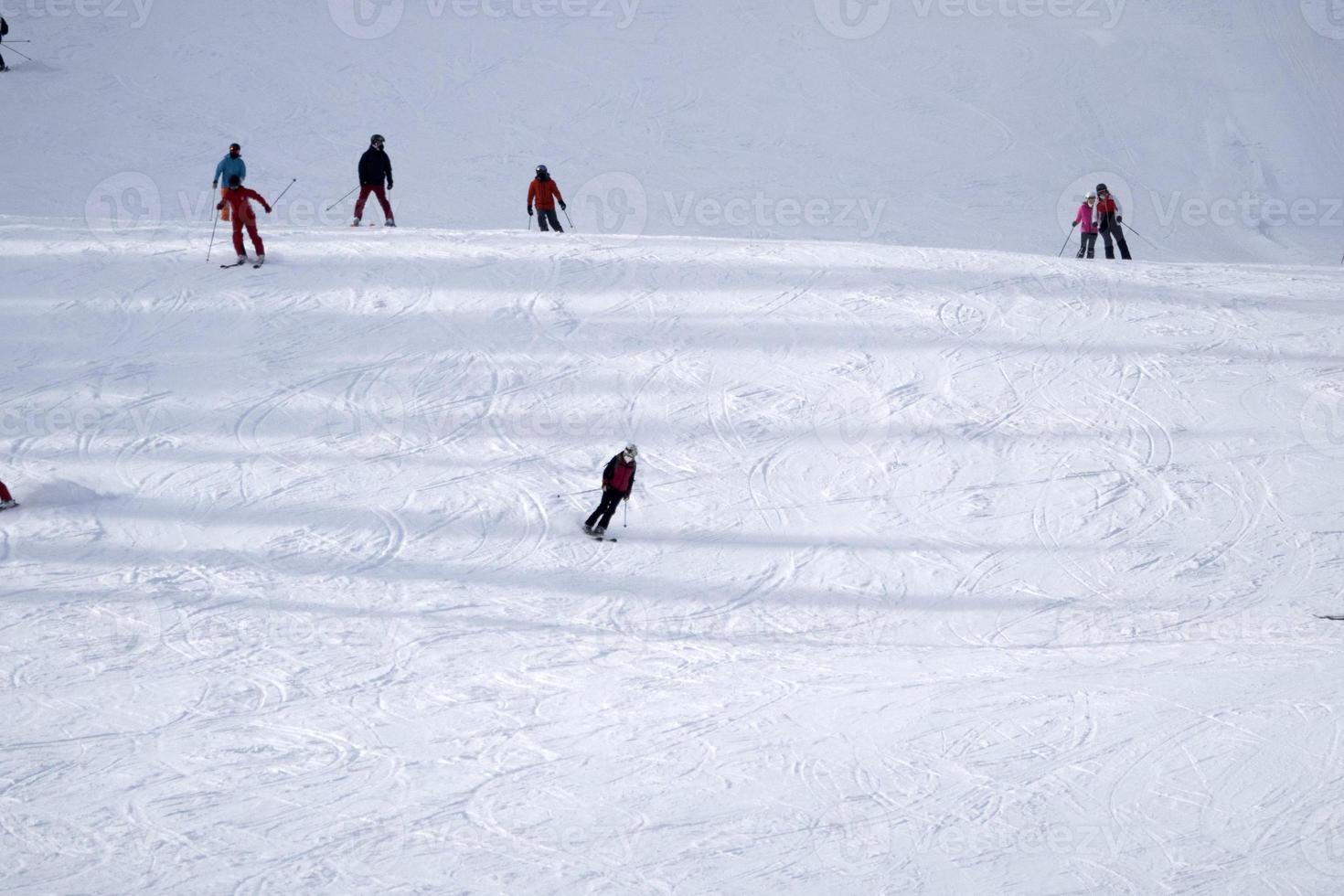 muitos esquiadores esquiando nas montanhas de neve do vale das dolomitas gardena foto