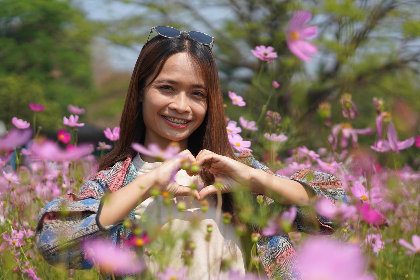 feliz ásia mulher dentro cosmos flor jardim foto