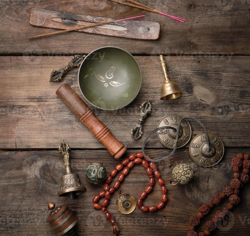 tigela de canto de cobre, contas de oração, tambor de oração e outros objetos religiosos tibetanos para meditação e medicina alternativa foto