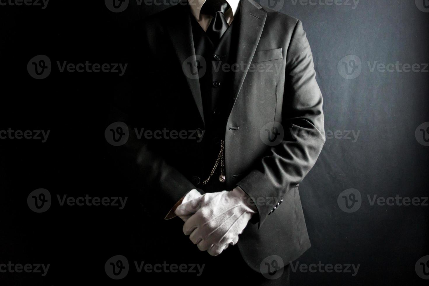 retrato de mordomo ou porteiro em terno formal preto e luvas brancas em atenção elegante. indústria de serviços e hospitalidade profissional. foto