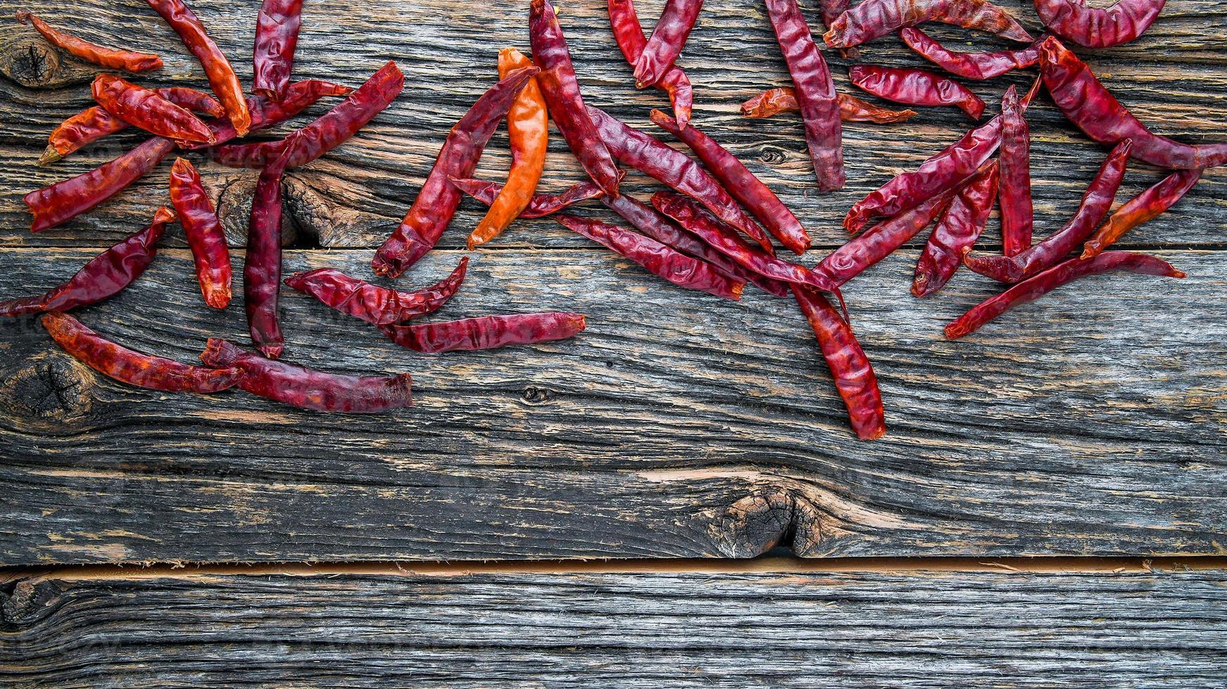 seco picante vermelho Pimenta em rústico de madeira fundo a partir de acima com cópia de espaço foto