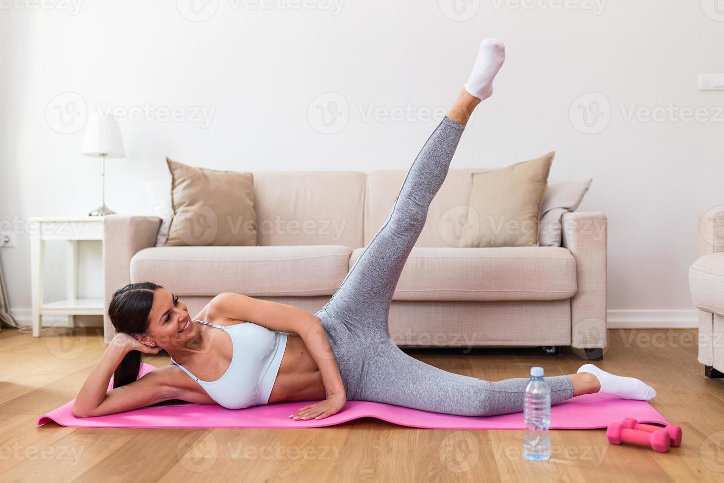 jovem mulher exercício às lar, alongamento. Tempo para ioga. atraente e saudável jovem mulher fazendo exercícios enquanto em repouso às lar. jovem mulher exercício em tapete às lar, interior foto