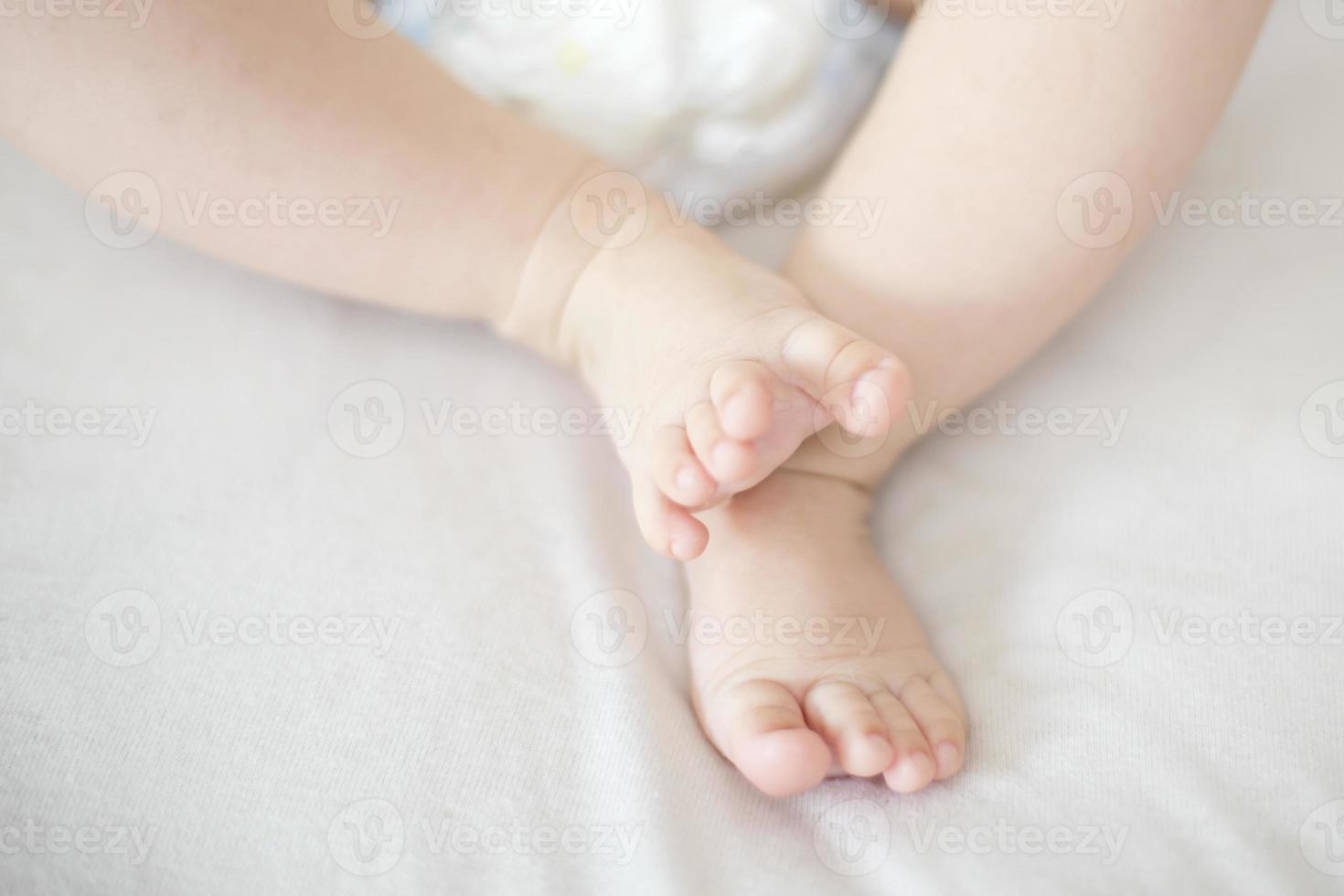 pés pequenos de menina na cama foto