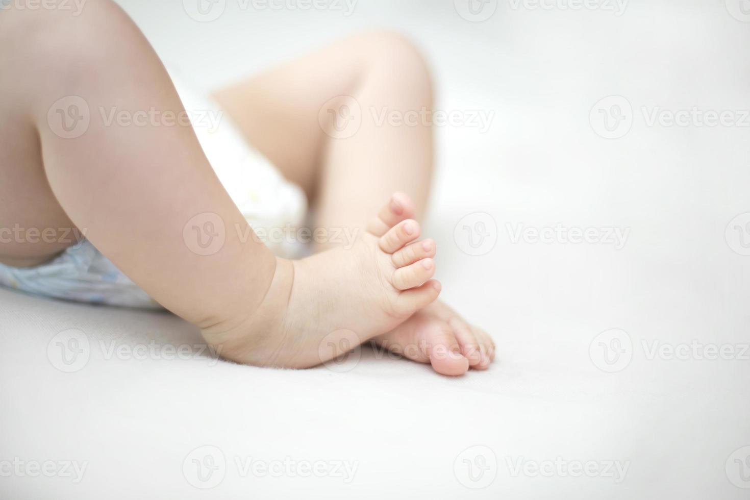 pés pequenos de menina na cama foto