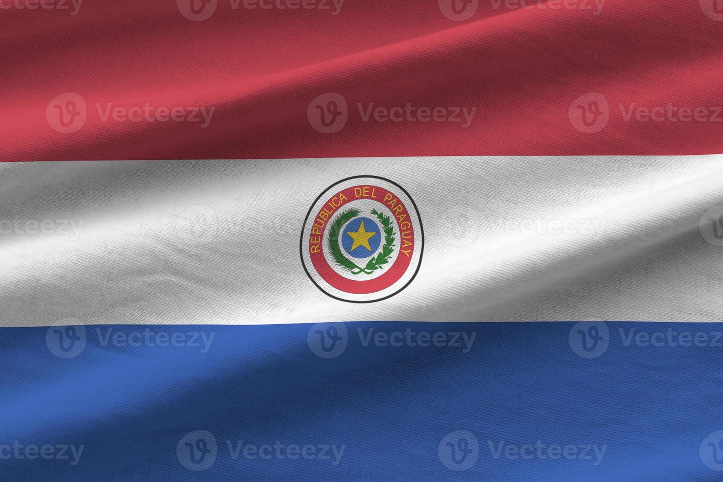 bandeira do paraguai com grandes dobras acenando perto sob a luz do estúdio dentro de casa. os símbolos e cores oficiais no banner foto