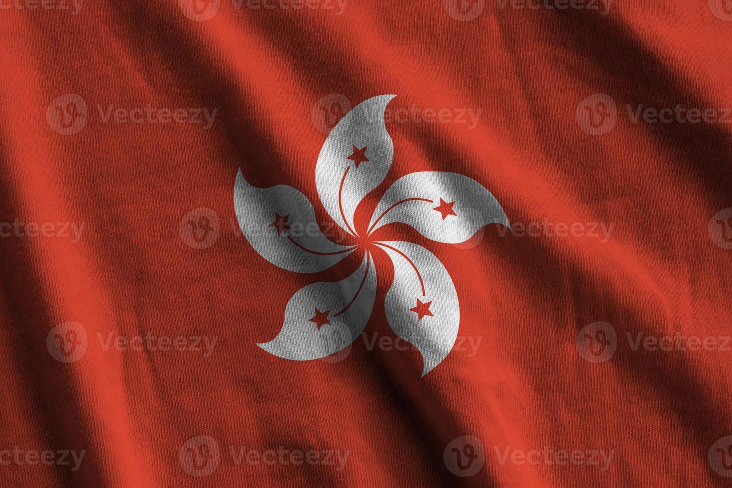 bandeira de hong kong com grandes dobras acenando perto sob a luz do estúdio dentro de casa. os símbolos e cores oficiais no banner foto