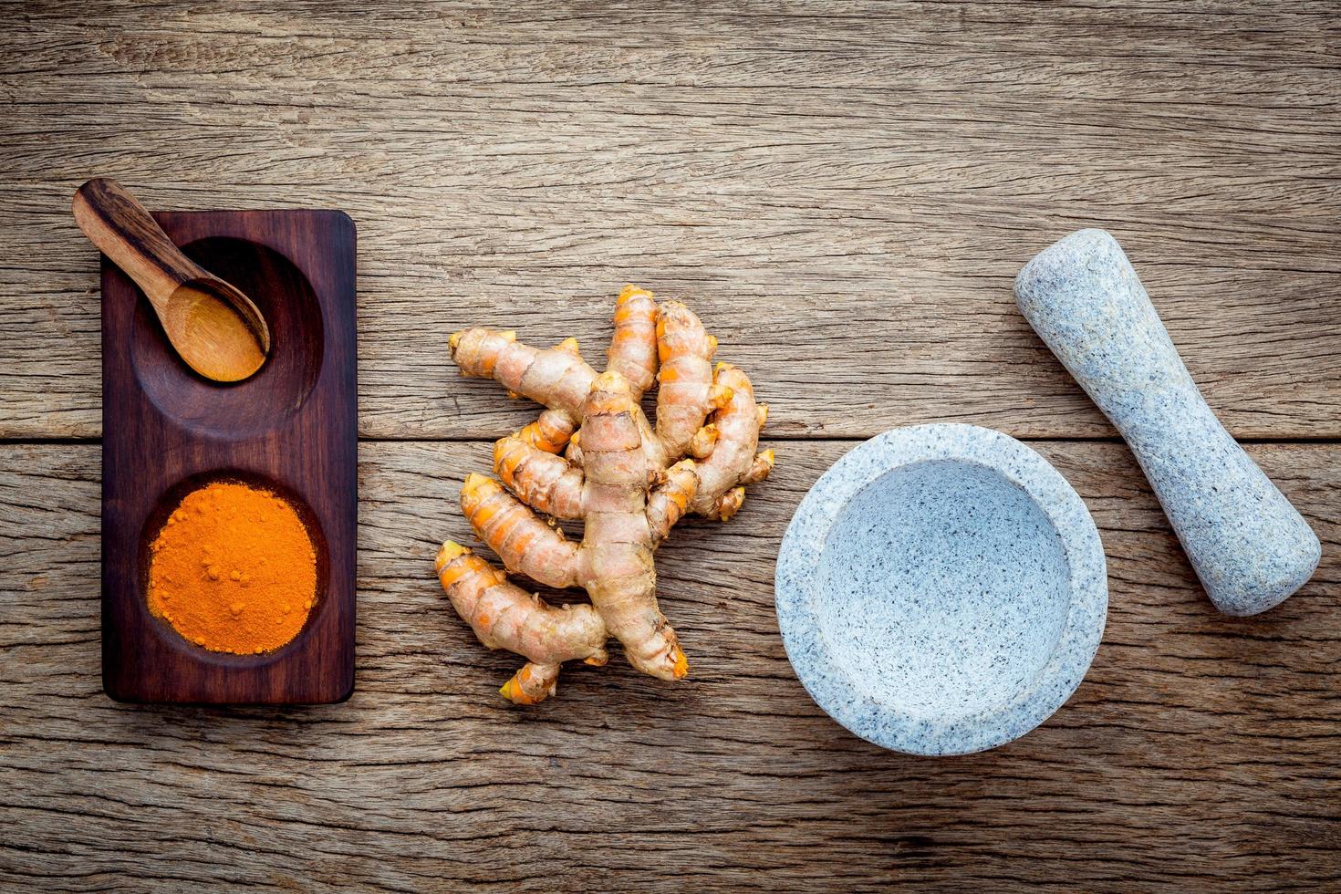 pó de curcumina e raízes com um almofariz foto