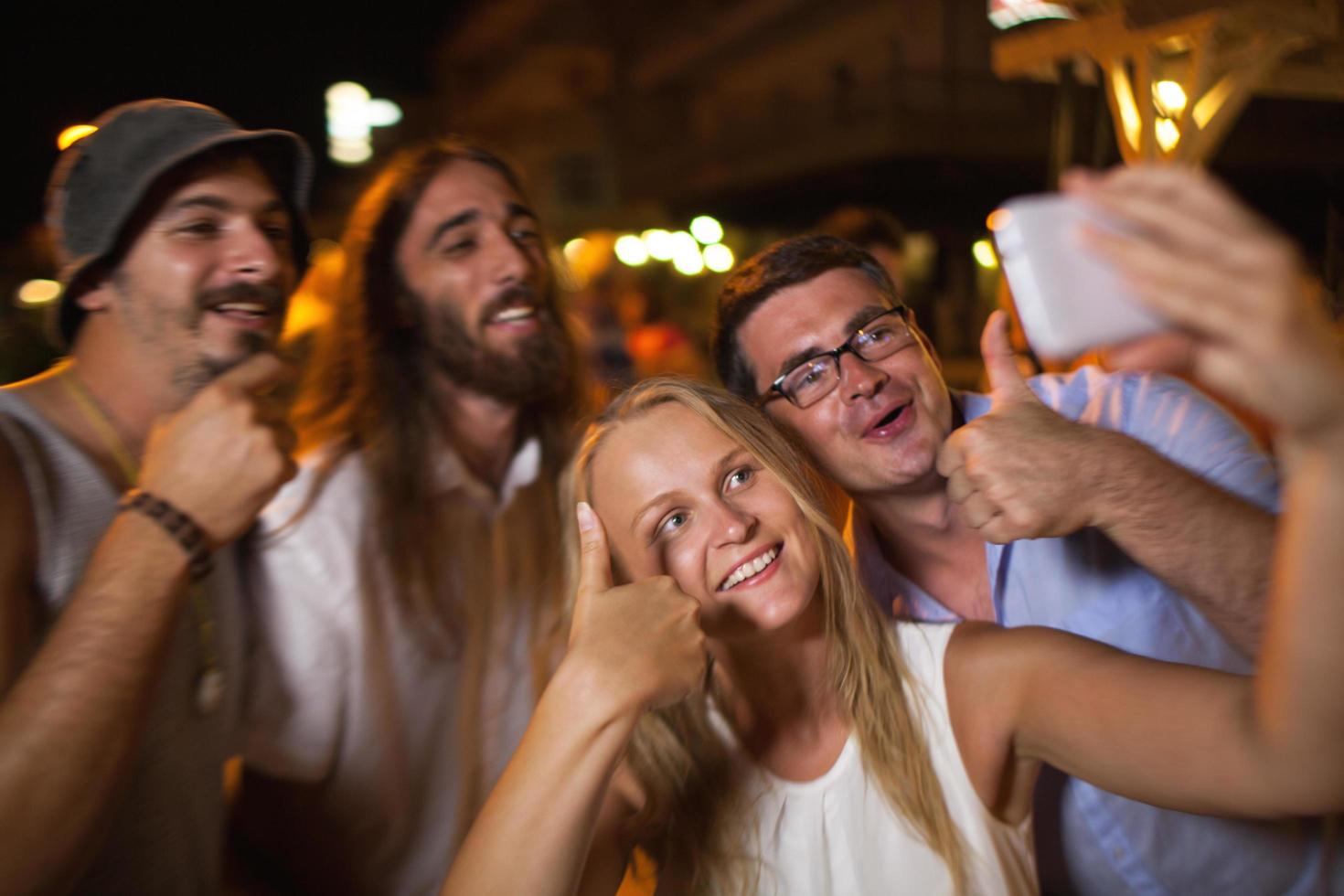 grupo tirando uma selfie à noite foto