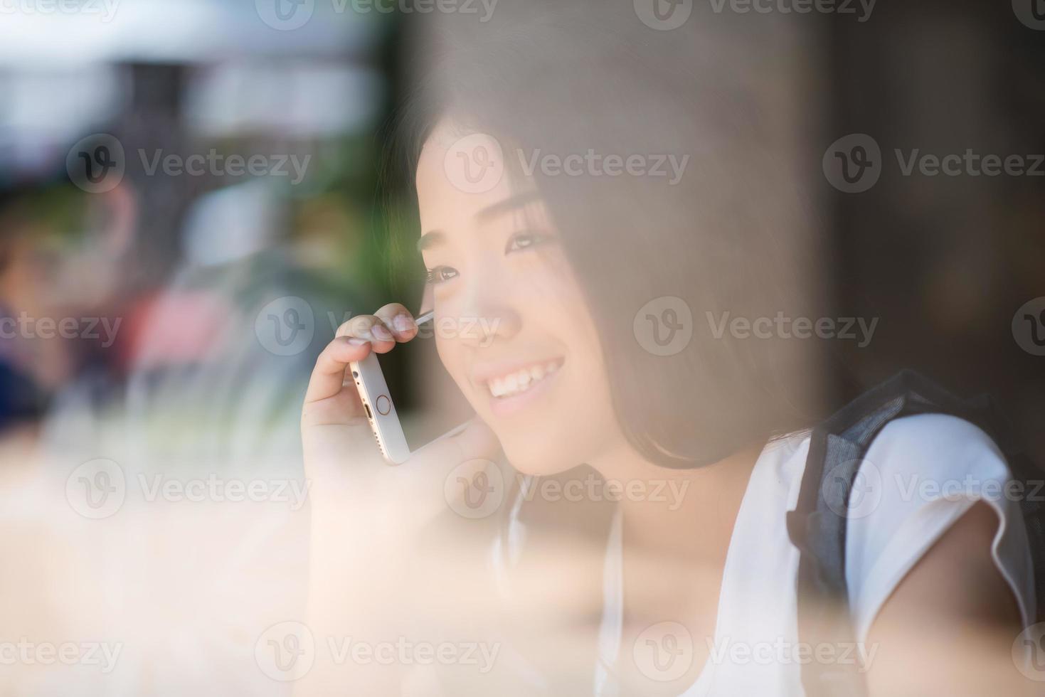 mulheres jovens usando e olhando para smartphone no café da janela foto