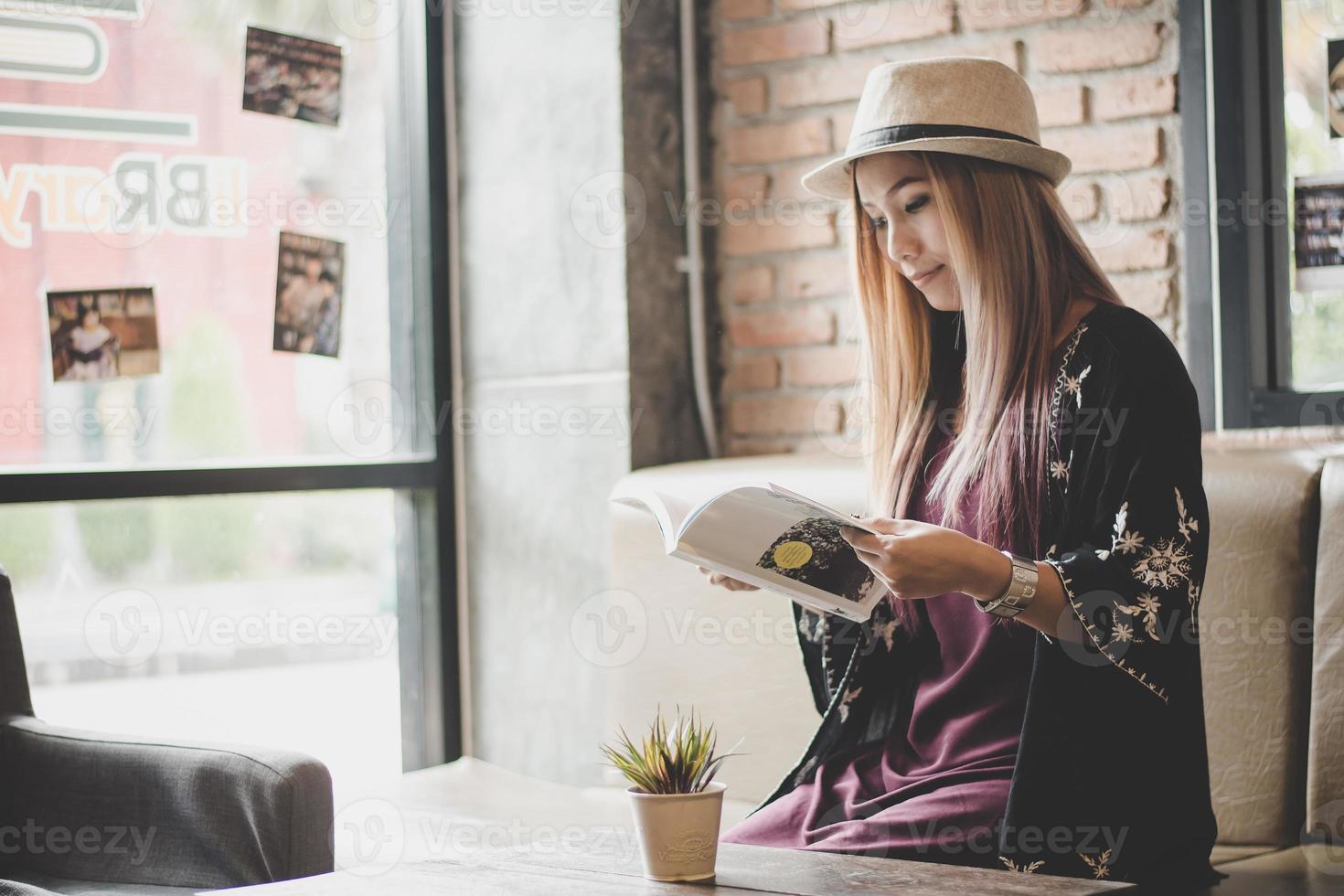 Mulher de negócios feliz lendo um livro enquanto relaxa no café foto