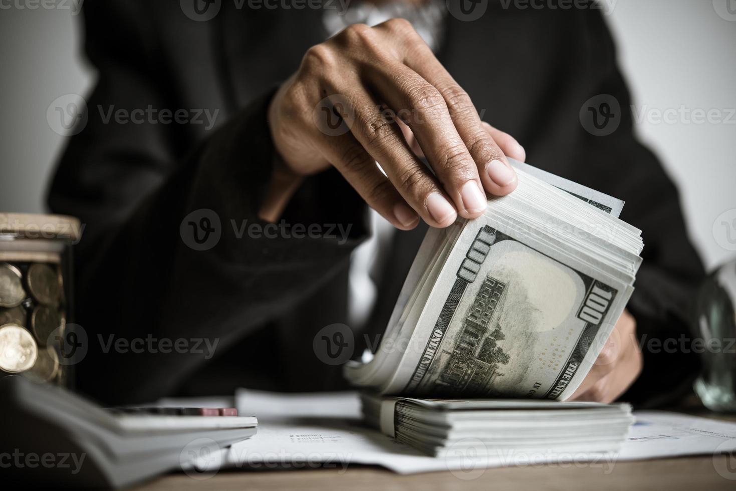 close-up de mãos de uma empresária segurando notas de dólar foto