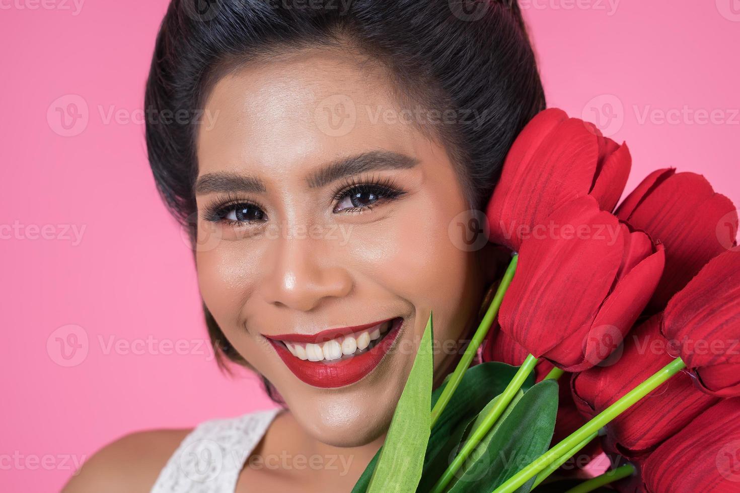 retrato de uma linda mulher com um buquê de flores de tulipa vermelha foto