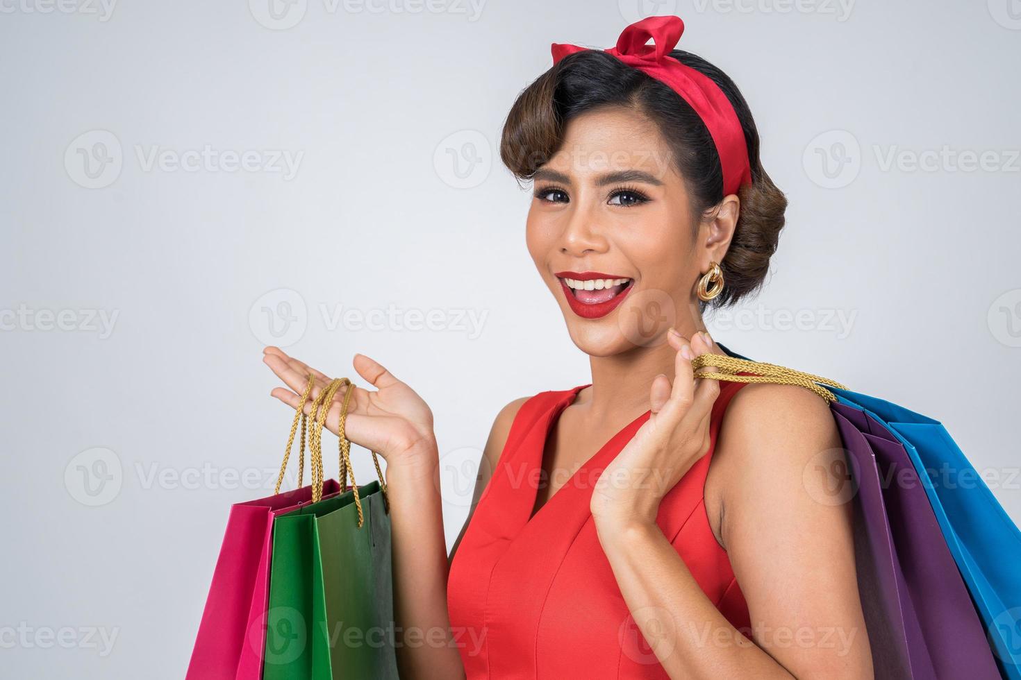 linda mulher asiática segurando sacolas coloridas foto