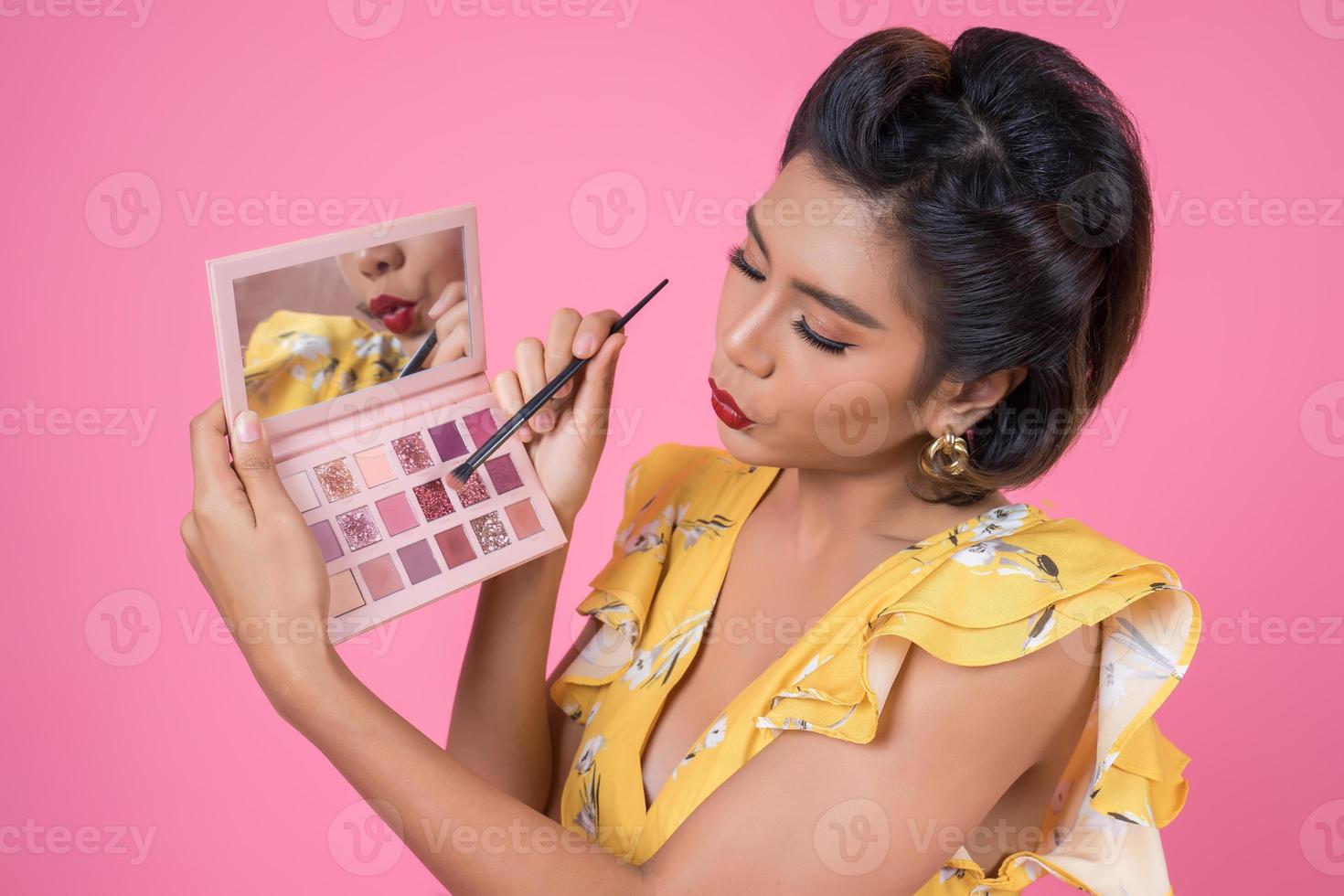 retrato de uma mulher com maquiagem e escova cosmética foto