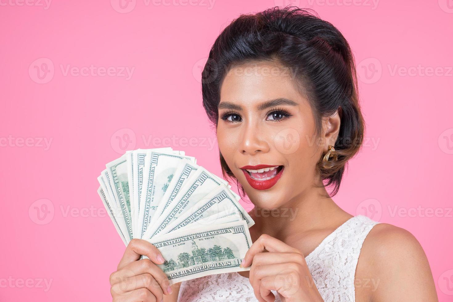 mulher bonita feliz segurando dólares foto