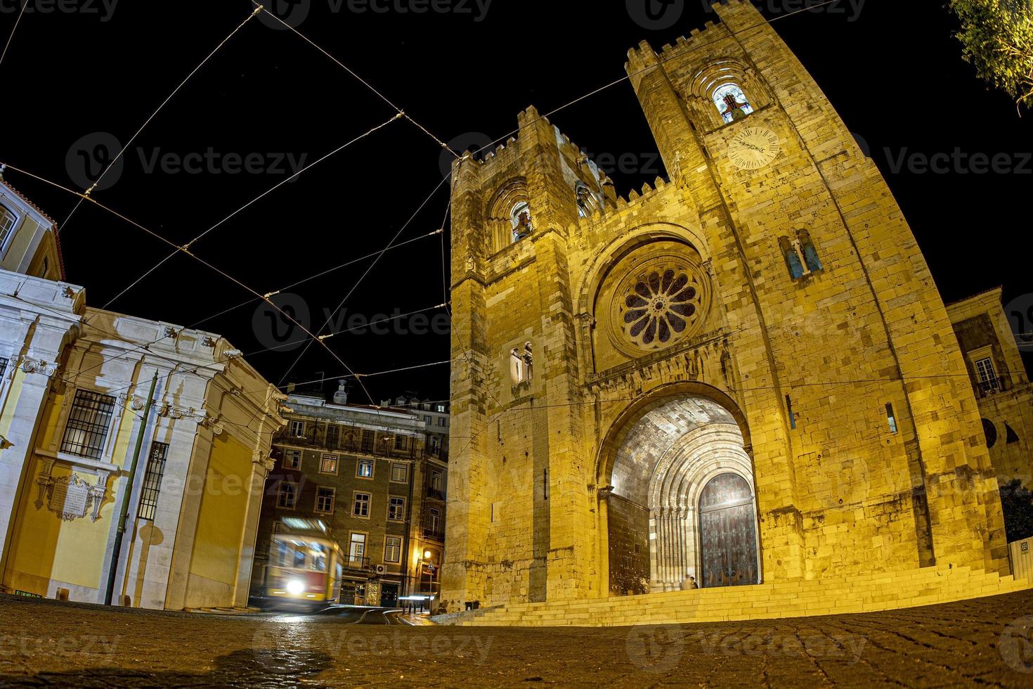visão noturna da catedral de lisboa com bonde foto
