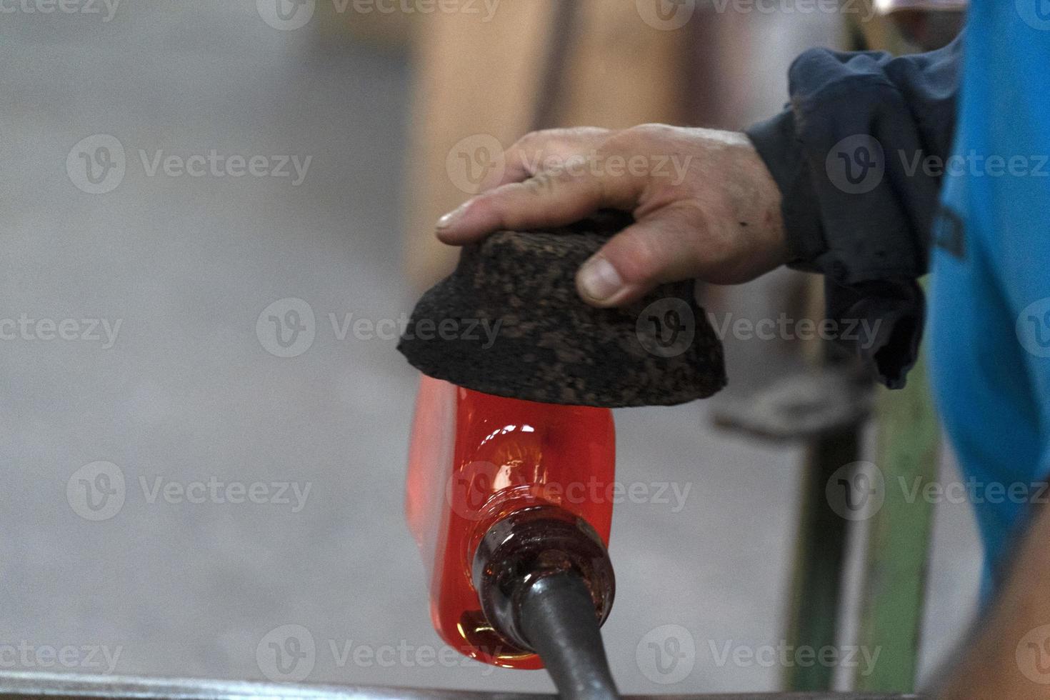 mestre de vidro enquanto trabalhava na fábrica de vidro do forno de murano veneza itália foto