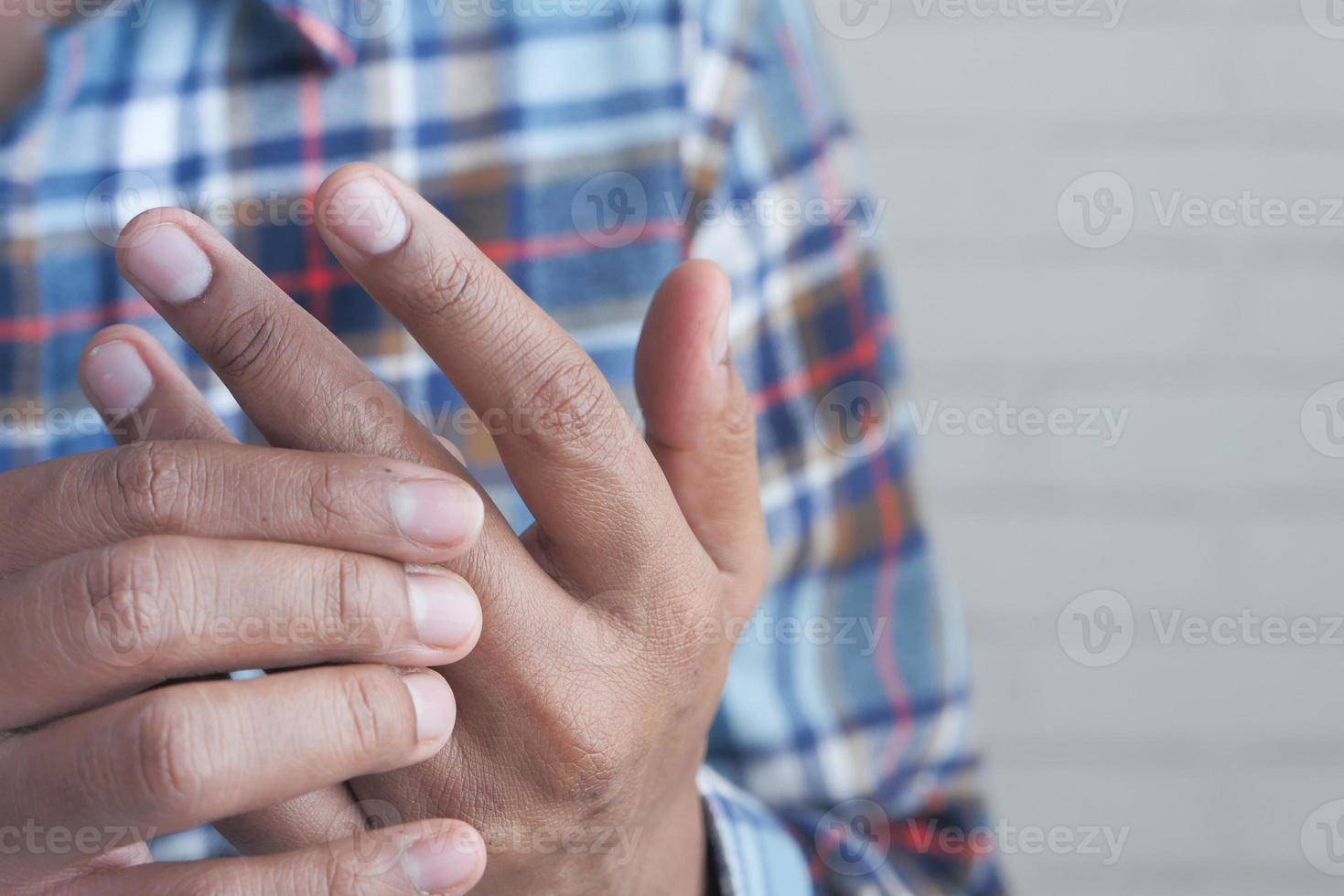 homem sentindo dor em close-up do dedo foto
