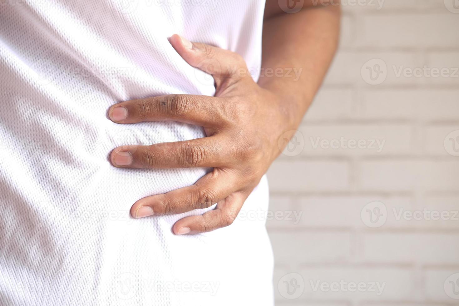 jovem com dor de estômago, close-up foto