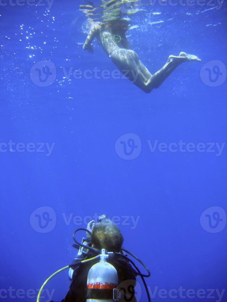 uma mergulho mergulhador se foi enquanto fotografando uma mergulhador a partir de embaixo da agua foto