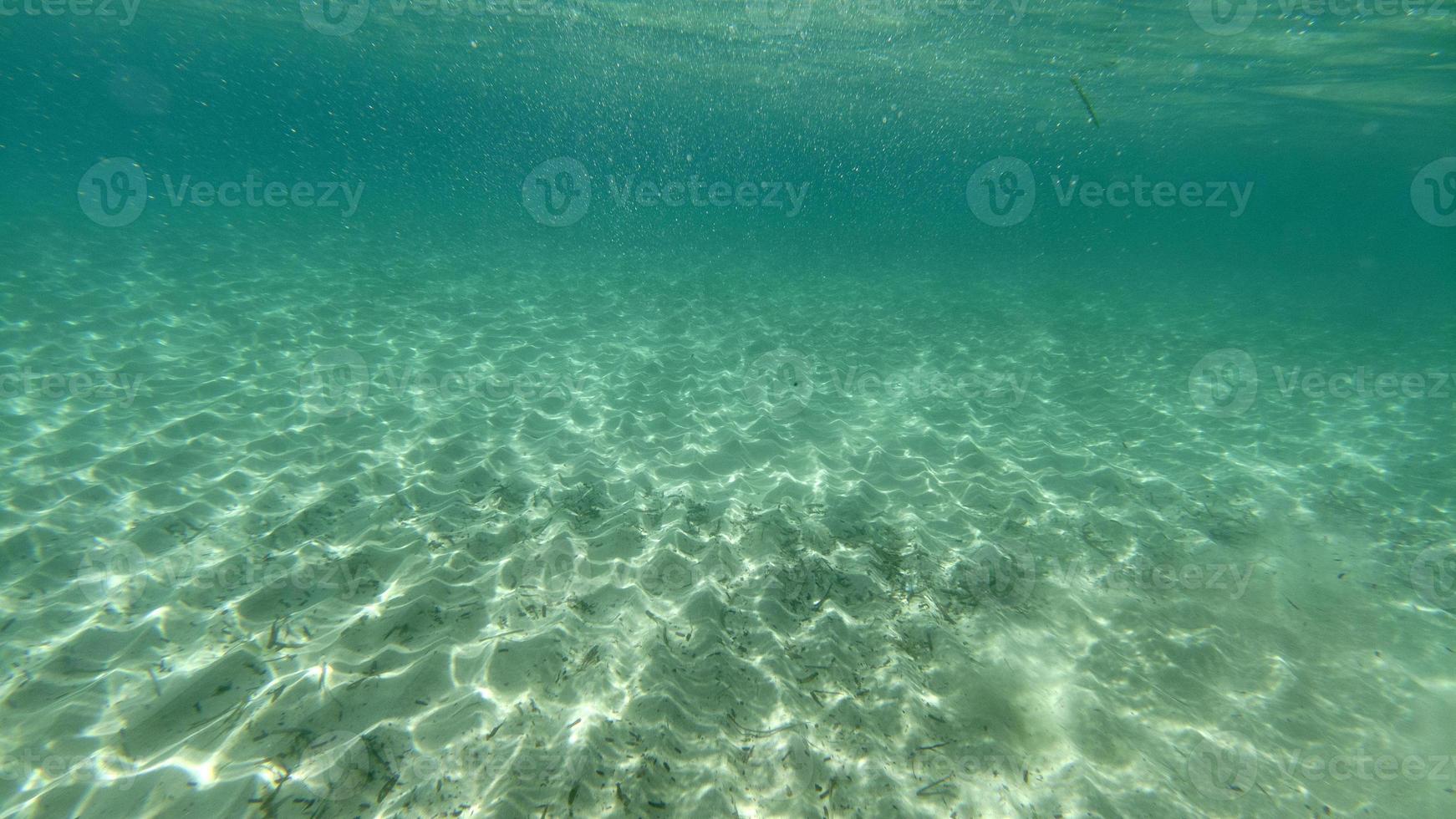 fundo de areia nadando debaixo d'água na lagoa azul-turquesa foto