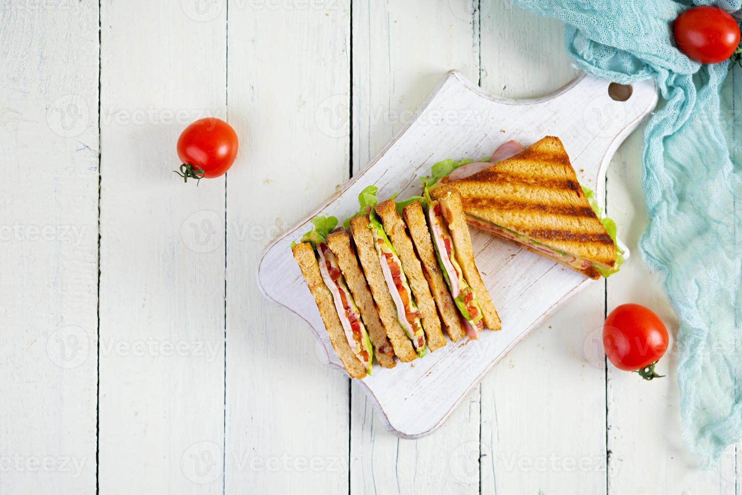 clube sanduíche com presunto, tomate, verde e queijo. grelhado panini. topo Visão foto