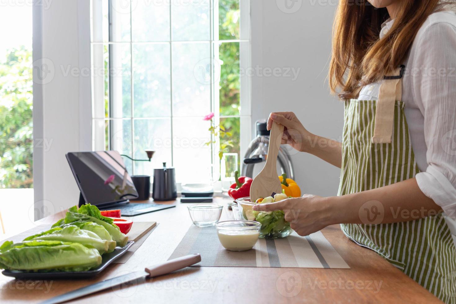 jovem mulher é fazer salada a partir de legumes ela tem preparado em mesa dentro dela casa cozinha para pegue salada este é limpar \ limpo e seguro Porque ingredientes estão cuidadosamente selecionado. saudável Comida preparação Ideias foto