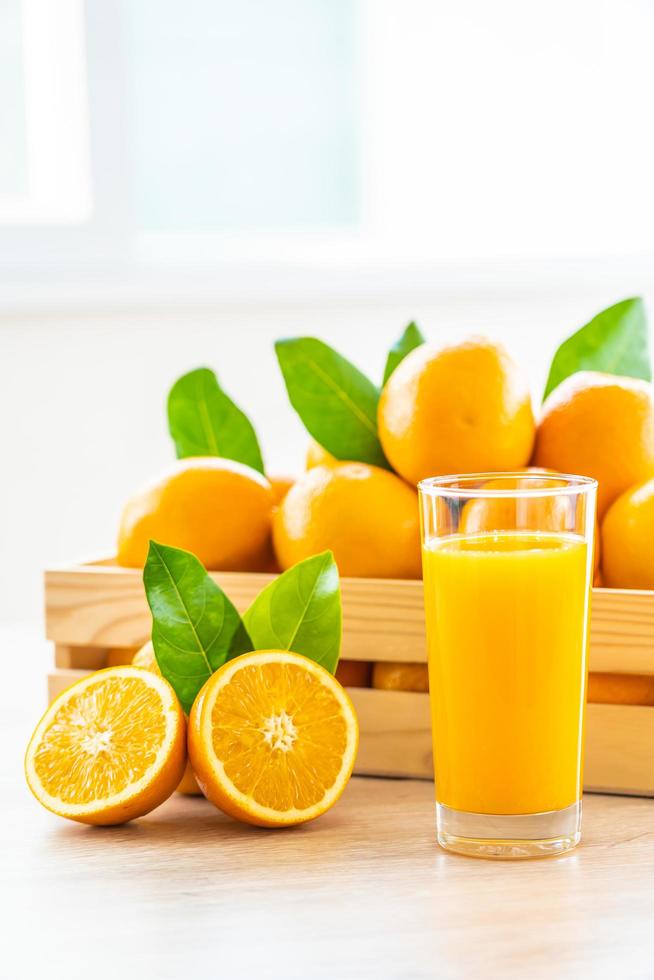 suco de laranja fresco e laranjas foto