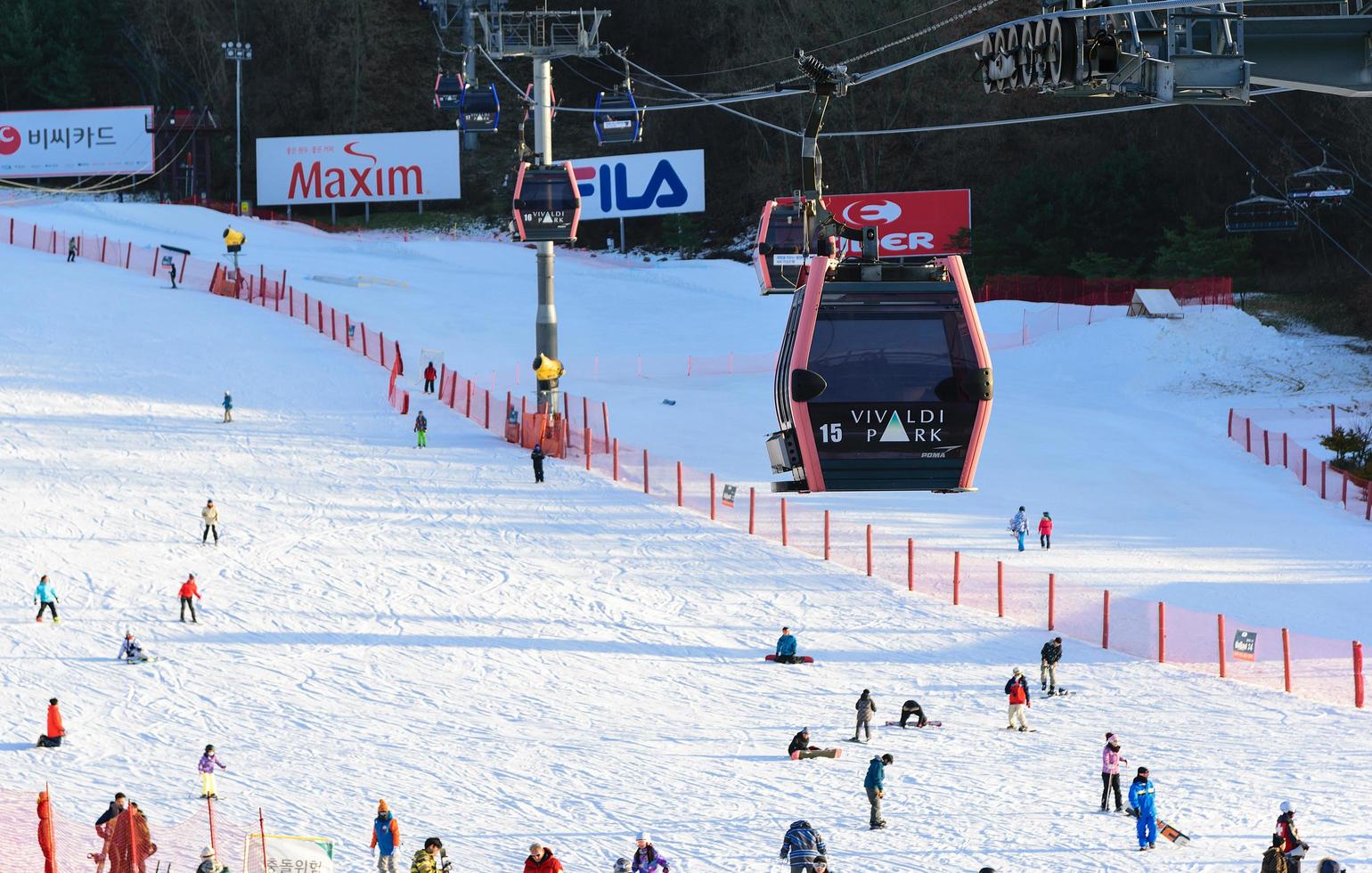 bonde do teleférico acima das pessoas na neve no vivaldi park ski world na coréia foto