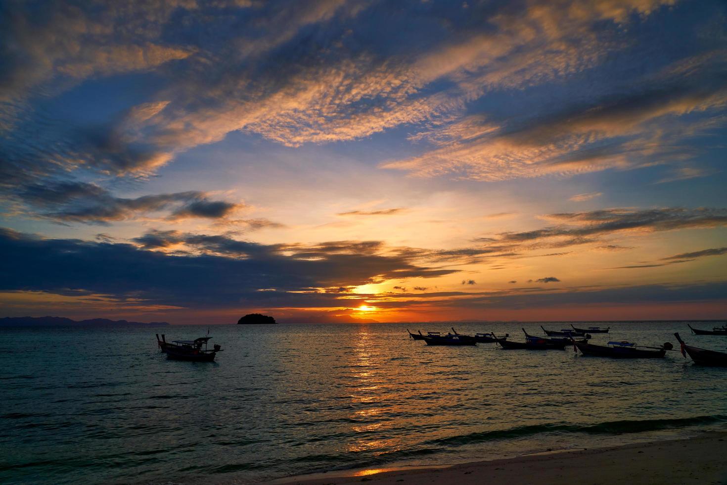 silhueta de barcos com nascer do sol nublado colorido foto