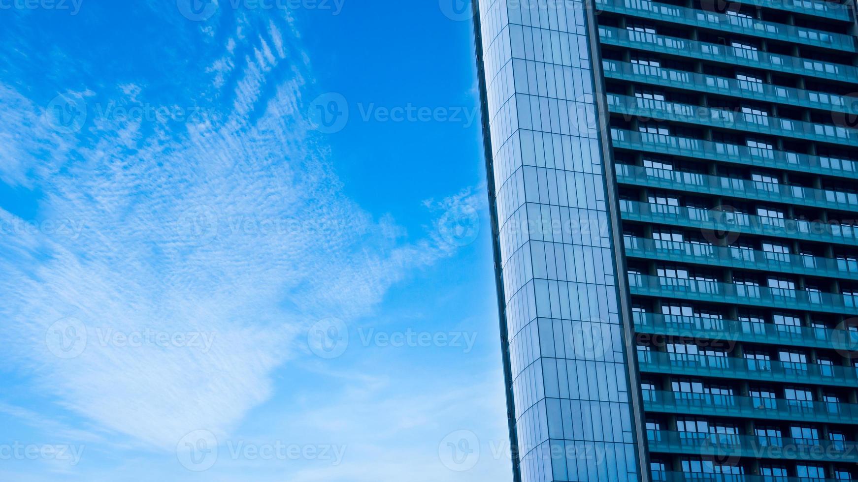 vidro construção com sacada com azul céu plano de fundo, abstrato parte do moderno arquitetura, vidro e concreto paredes foto