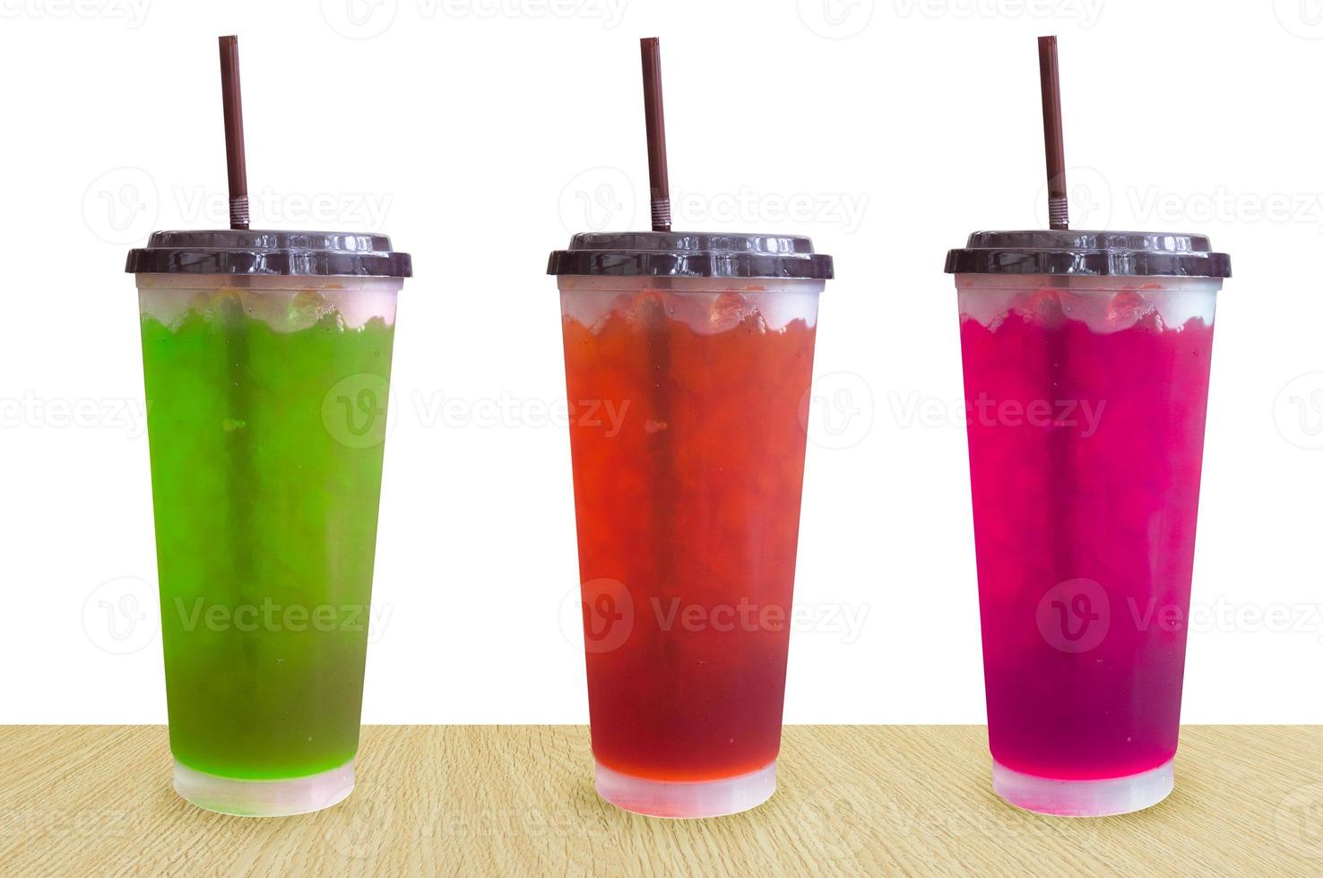 água doce fresca colorida brilhante e gelo em vidro plástico isolado no fundo branco, bebidas de verão com gelo no fundo branco foto