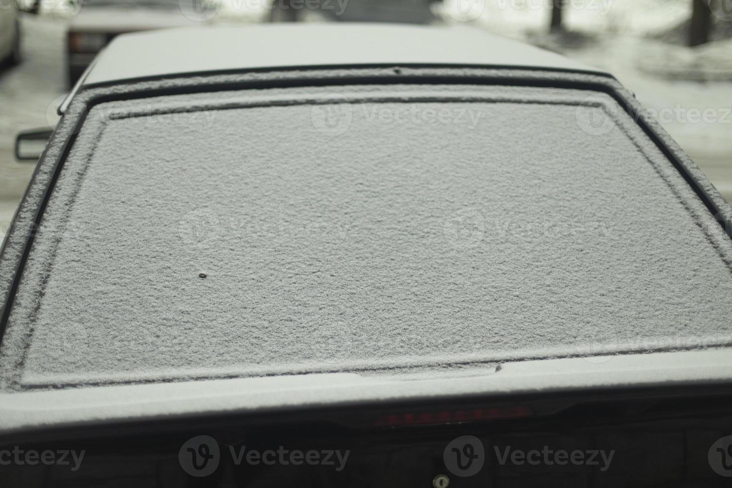 traseiro janela do carro dentro neve. neve de carro. carro é estacionado dentro inverno. foto