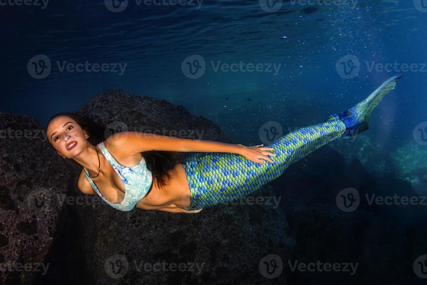 bela sereia nadando debaixo d'água no mar azul profundo foto