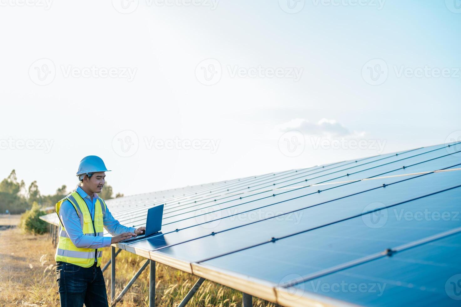 homem jovem técnico trabalhando no laptop na fazenda solar foto