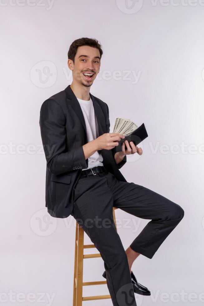 animado jovem homem colocando notas para dentro carteira isolado branco estúdio fundo foto