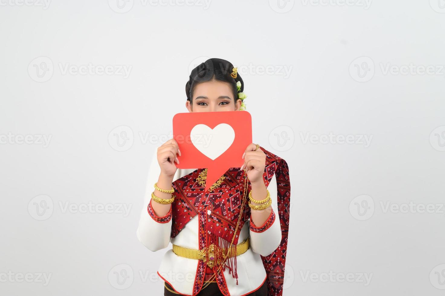 jovem lindo mulher dentro tailandês lanna traje com cartão cartão dentro coração símbolo foto
