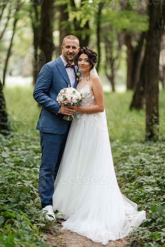 Casamento andar do a noiva e noivo dentro a decíduo floresta dentro verão foto