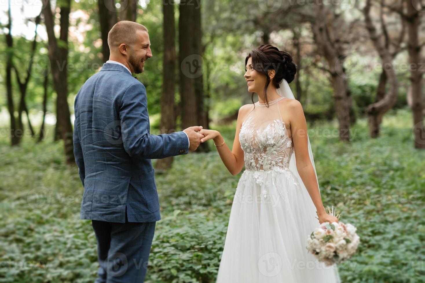 Casamento andar do a noiva e noivo dentro a decíduo floresta dentro verão foto