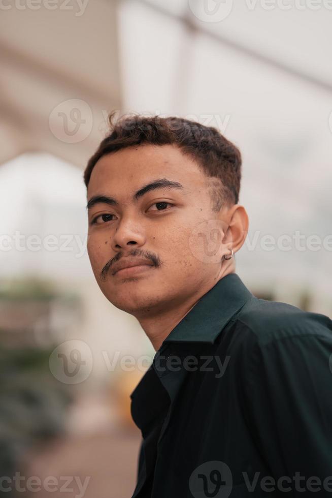 a ásia homem com uma bonito face e bigode vestindo uma Preto camisa enquanto relaxante foto