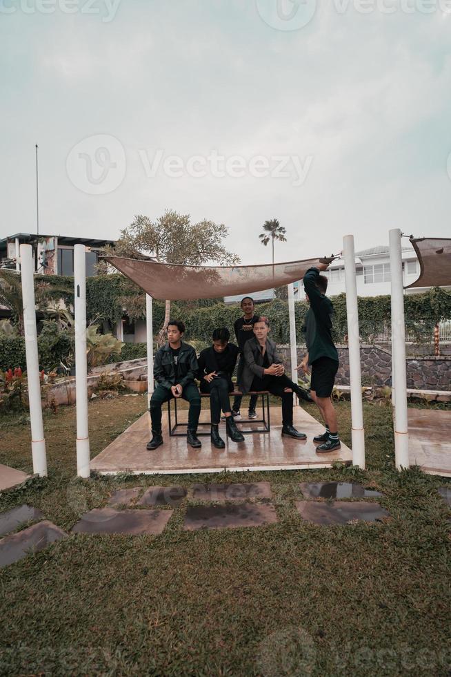 uma grupo do ásia adolescentes dentro Preto roupas estilizado Como danadinho crianças enquanto encontro às uma cafeteria foto