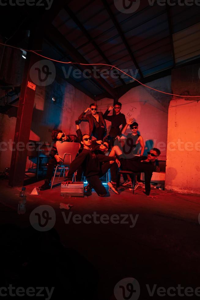 uma grupo do bandidos vestindo Sombrio roupas e óculos estavam tendo Diversão conversando com seus amigos dentro a velho construção foto