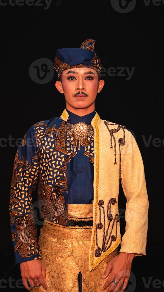 a ásia homem vestindo uma tradicional indonésio dança traje é Castanho e dele face é cheio do Maquiagem foto