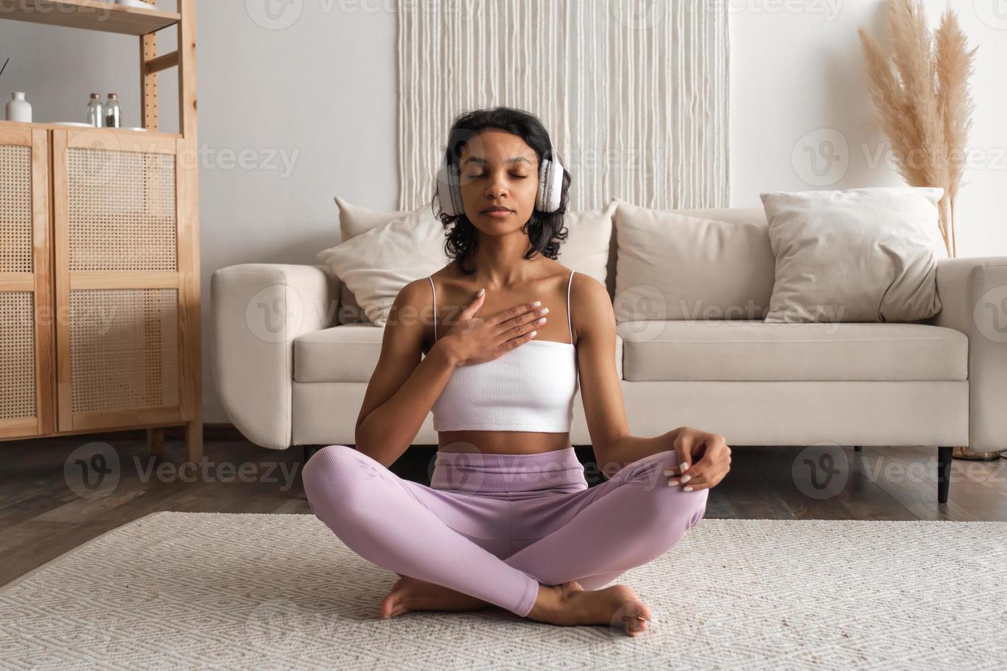 saudável Preto africano mulher às casa fazendo ioga, meditando e respiração dentro a manhã. bem estar saúde conceito foto
