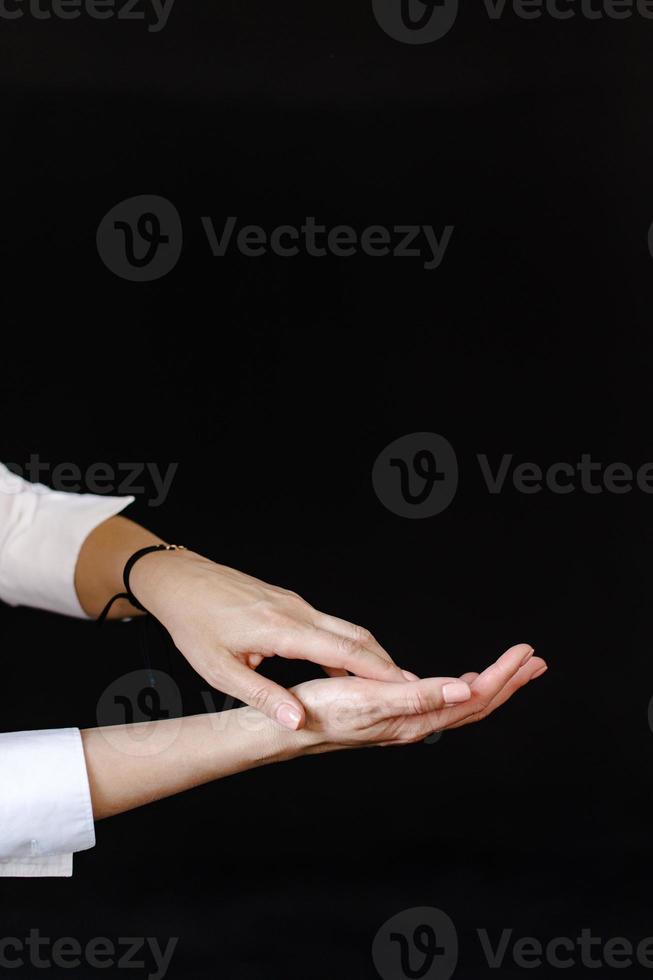 mulheres mãos com uma pulseira em uma Preto fundo foto