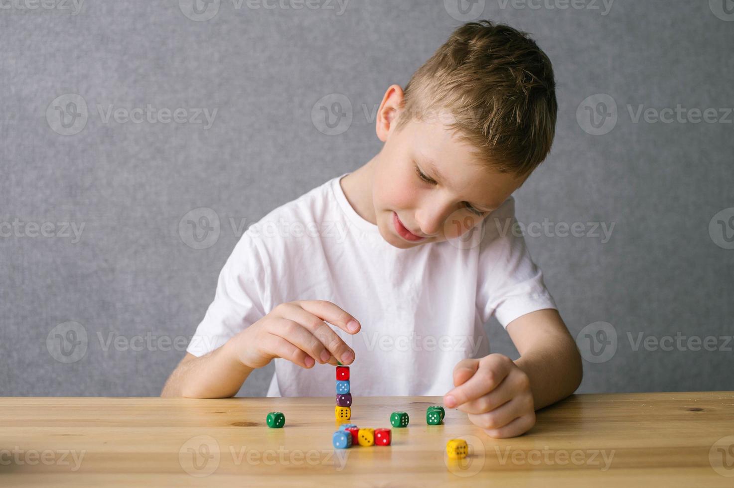 uma Garoto é jogando com colorida jogando cubos, construção uma torre foto