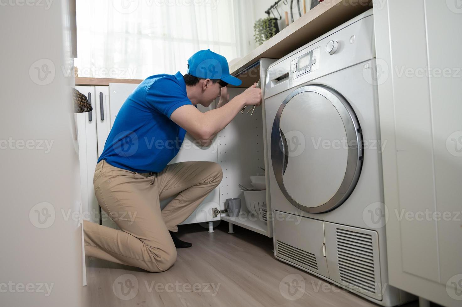 a ásia jovem técnico serviço homem vestindo azul uniforme verificação elétrico eletrodomésticos dentro casa foto