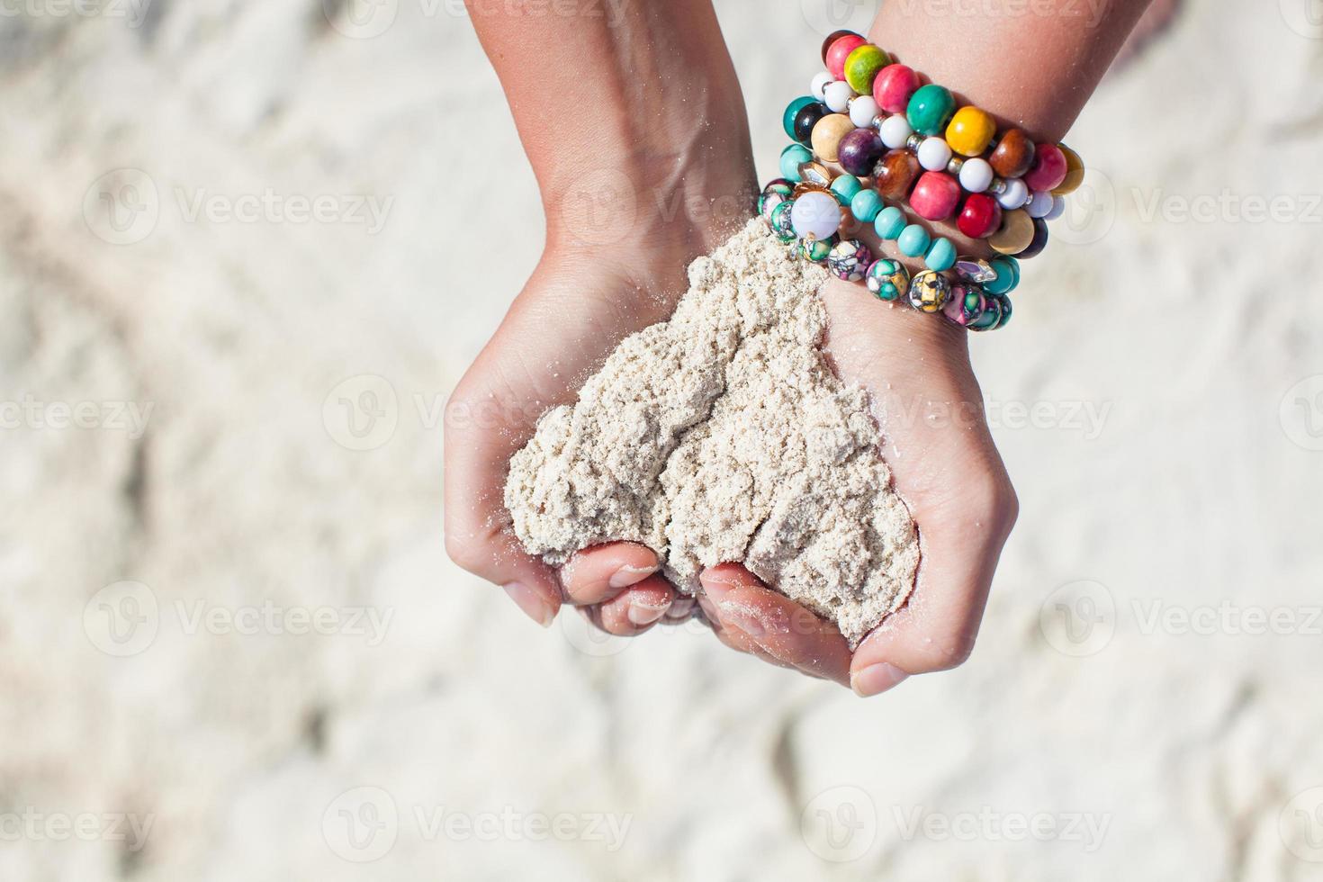 mãos segurando areia em uma coração forma foto