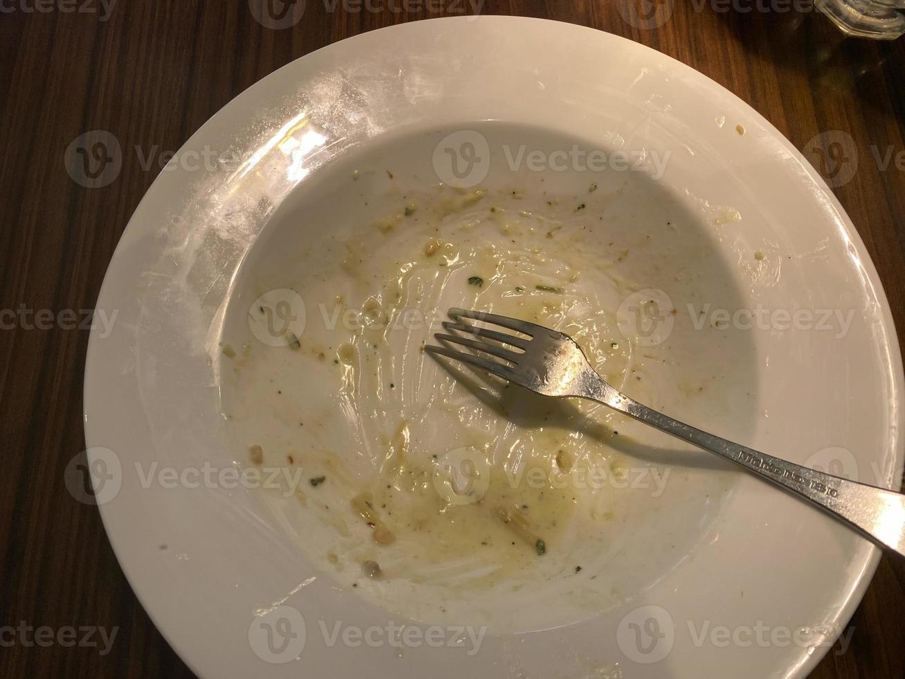 sujo prato com Comida sobras em de madeira fundo, topo Visão foto