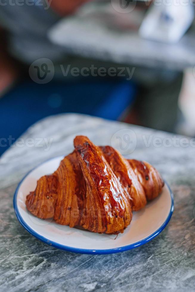 croissant dentro uma branco pequeno prato foto